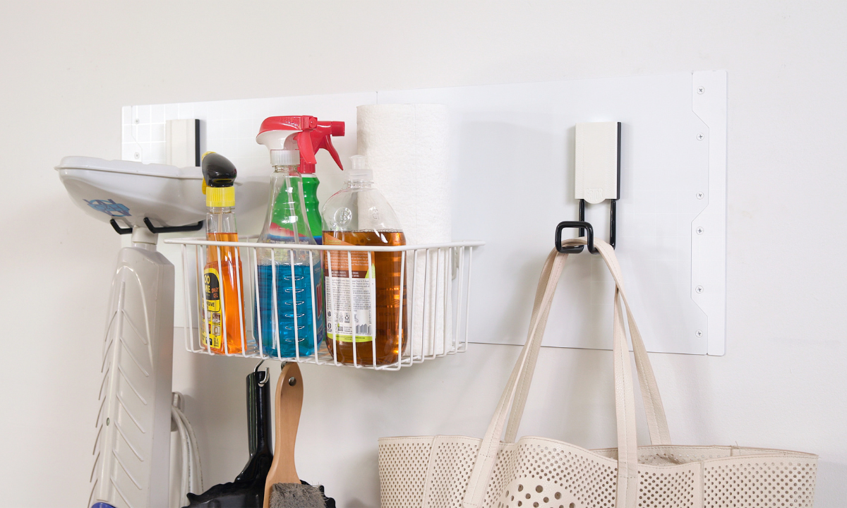 White Gator Steel Wall Panel with a magnetic basket holding spring cleaning supplies.