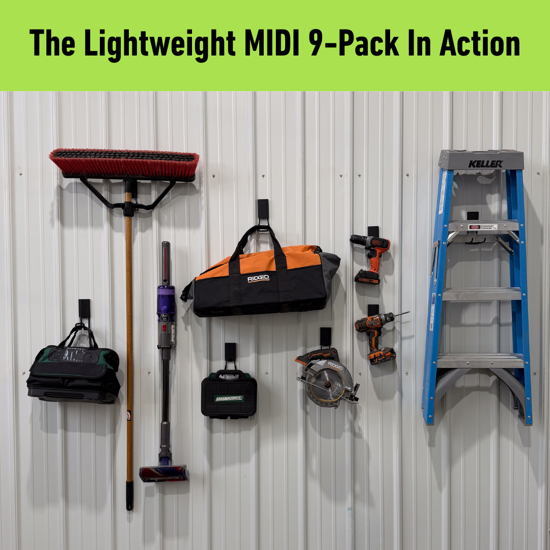 Various power and hand tools, tool bags, a broom, and a blue ladder are neatly hanging on a vertical white pole barn steel wall using red hooks from Gator Magnetics, showcasing versatile, tool-free organization with strong hold.