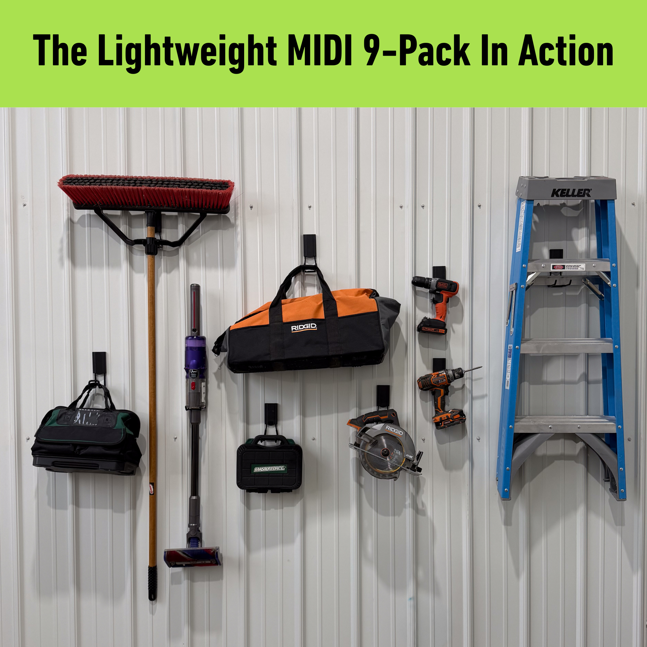 Various tools including a broom, cordless vac, power drills, a tool bag, battery packs, circular saw, and a foldable ladder are hung with red Gator Magnetics Magnetic Hooks on a flat, white pole barn steel wall, demonstrating heavy-duty magnetic storage without permanent installation or damage.
