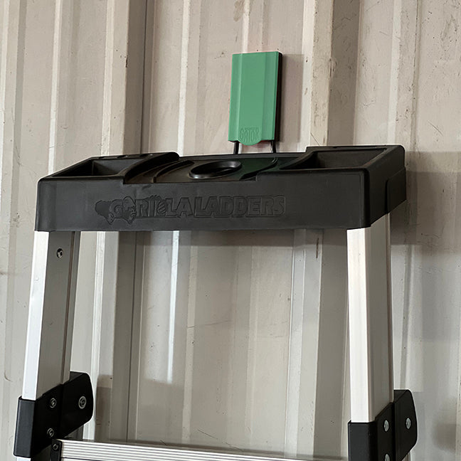 Green 2.5-inch open hook holding a ladder, designed for organizing large and heavy items. This hook is perfect for efficiently storing ladders, equipment, and other bulky tools in your garage or workshop. Its durable construction and bright color provide both functional and aesthetic benefits, enhancing the organization and accessibility of your workspace.