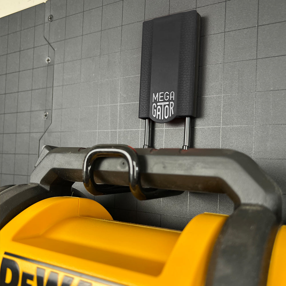 A sturdy black 3-inch closed magnetic hook holding a DeWalt battery pack, demonstrating its heavy-duty capacity. This hook is perfect for securely storing power tool accessories, batteries, and other items in garages, workshops, and industrial settings. Its robust construction ensures that even heavy items are stored safely and within easy reach, promoting a well-organized and efficient workspace.