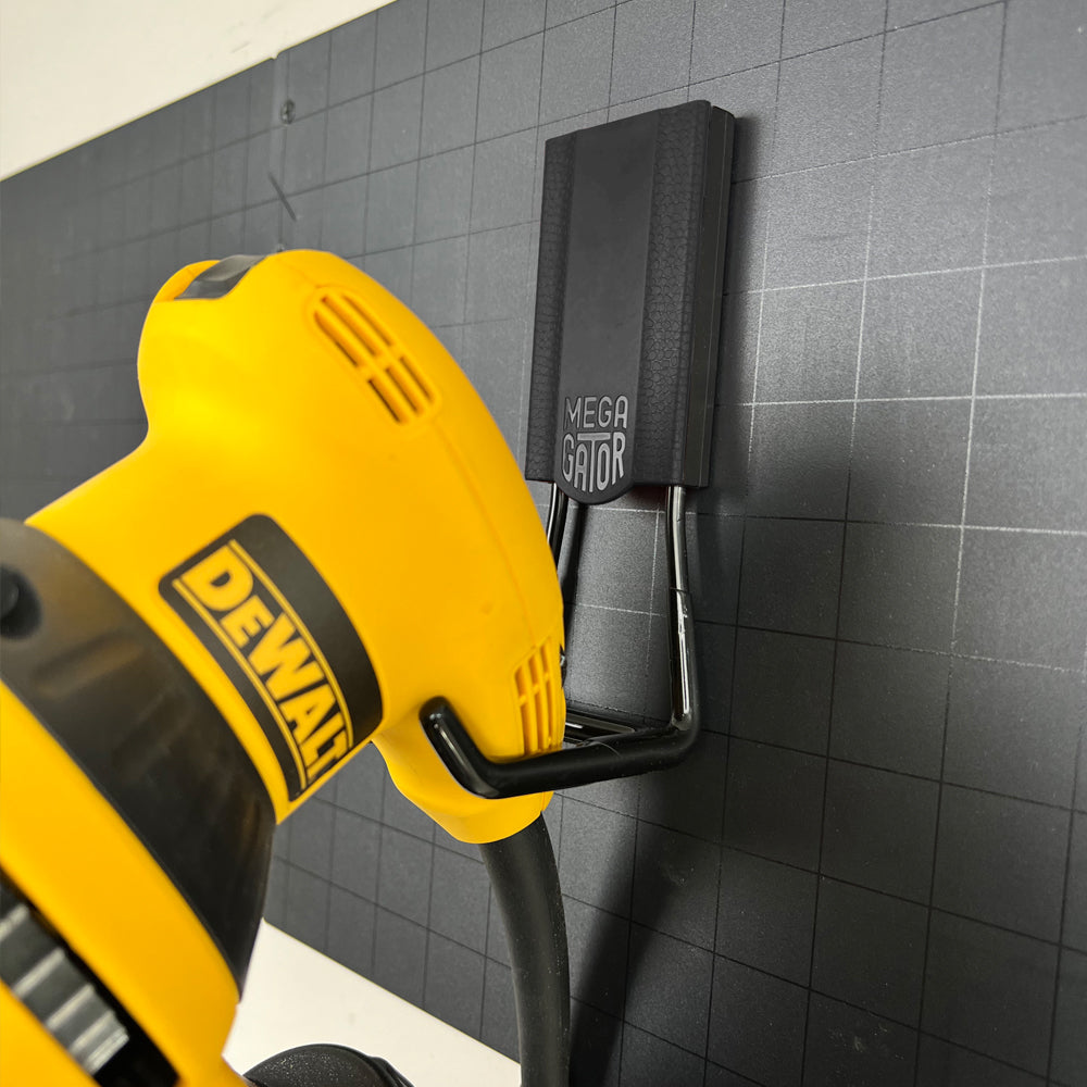 The Dewalt sander is securely hanging from a black 4.5" open hook, demonstrating the hook’s strength and durability. Ideal for storing heavy tools and equipment, this image highlights the hook’s capacity and reliability for maintaining an organized workspace.