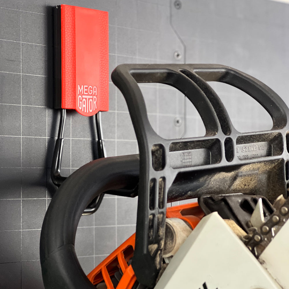 A Gator Magnetics Magnetic Hook holds the handle of a chainsaw against a flat steel van interior panel, demonstrating secure, tool-free van tool storage.