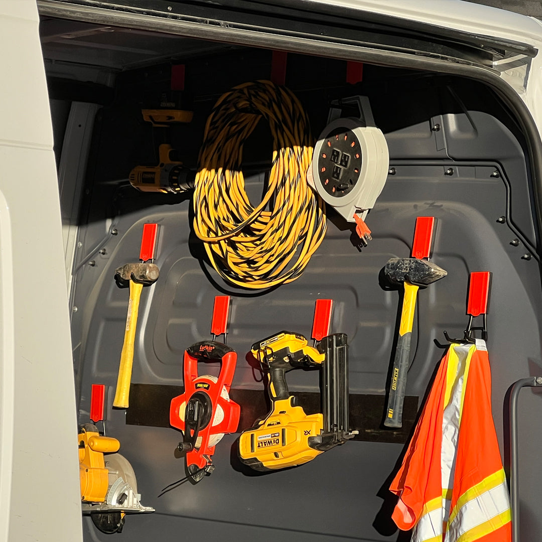 Gator Magnetics 4-inch Open Hooks mounted on steel interior of utility van, holding hammers, saw, nail gun, extension cord, safety vest, and power tools for mobile job site organization.