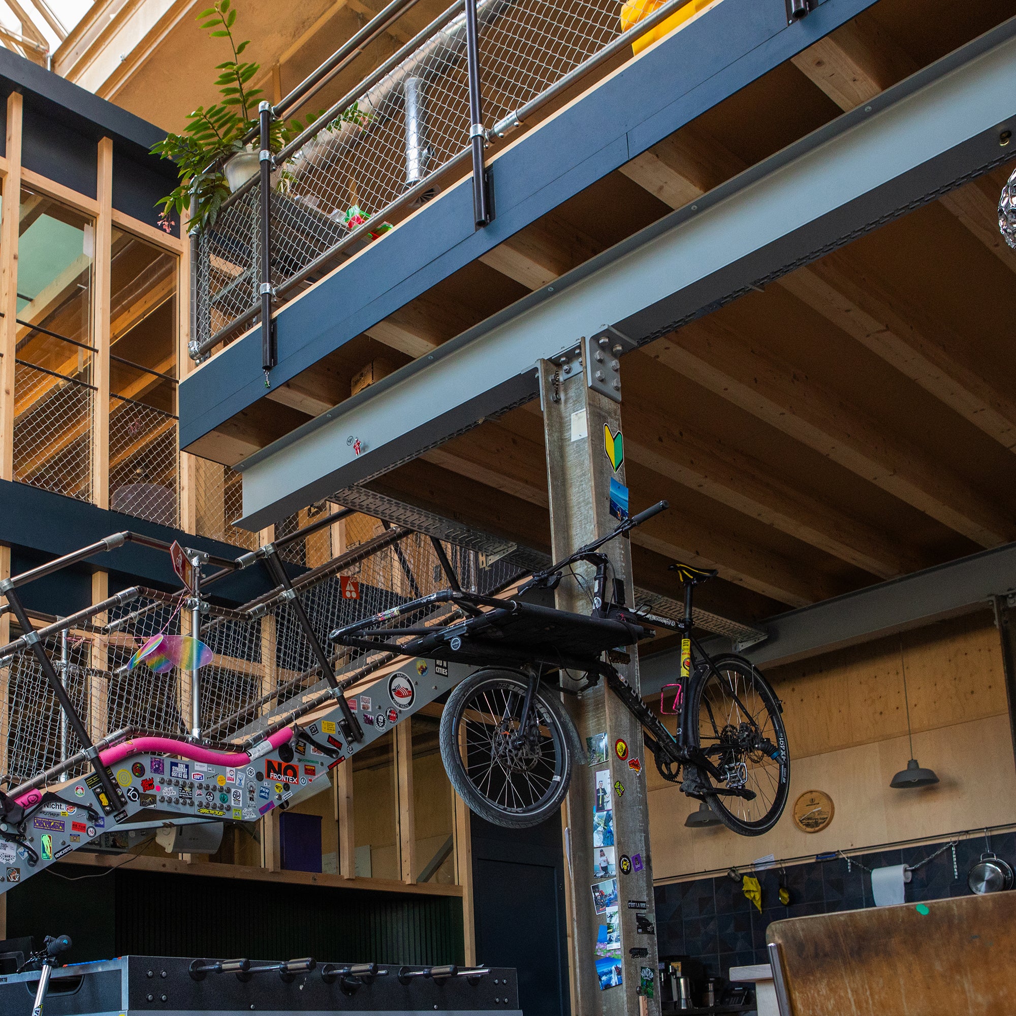 Bicycle suspended from black Gator magnetic hooks on a galvanized steel column.