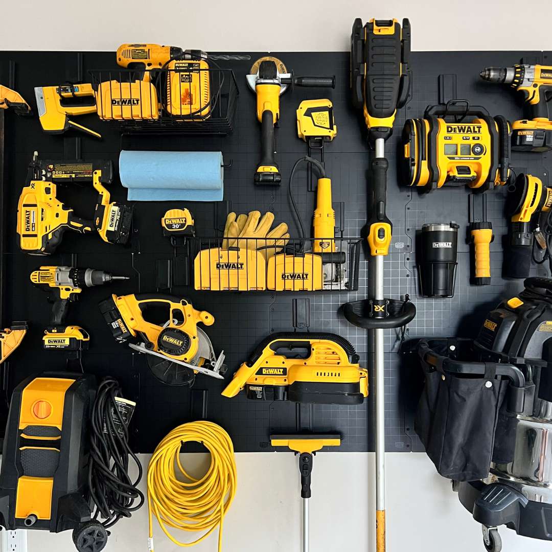 DEWALT power tools, gloves, paper towels and cords organized on a black Gator Steel Wall Panel.