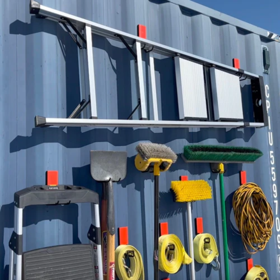 Gator Magnetics heavy duty magnetic hooks organizing ladder, shovels, brooms, hoses, and tools on steel shipping container wall for efficient outdoor tool storage