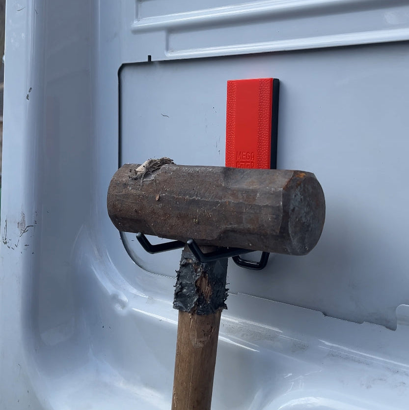A Gator Magnetics hook holds a large sledgehammer on a smooth, flat, steel van interior panel, demonstrating heavy-duty tool storage and microfiber towel storage potential in a compact work vehicle.