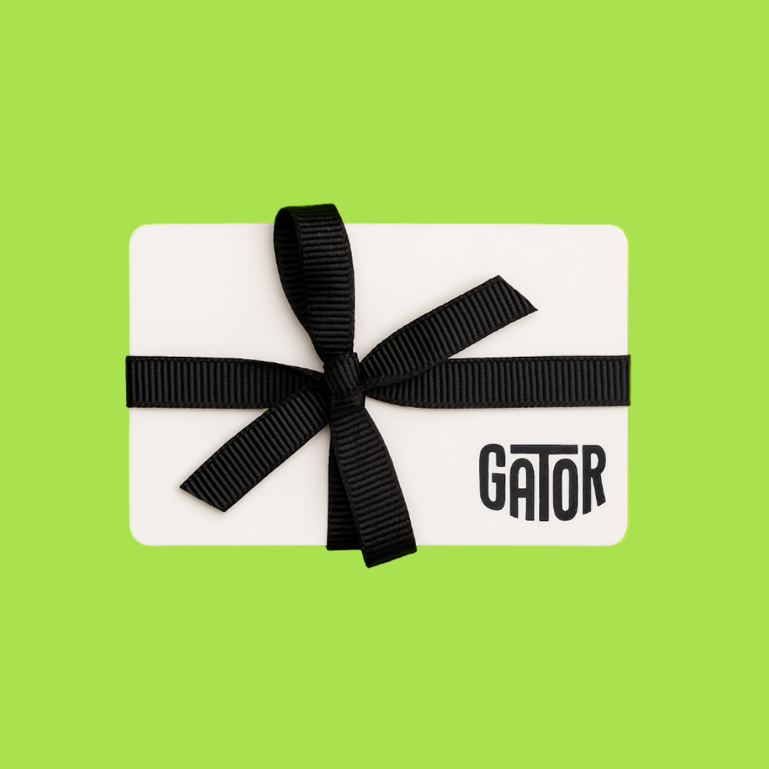 A white rectangular Gator Magnetics gift card with a black ribbon tied in a bow around it is set against a solid bright green background.