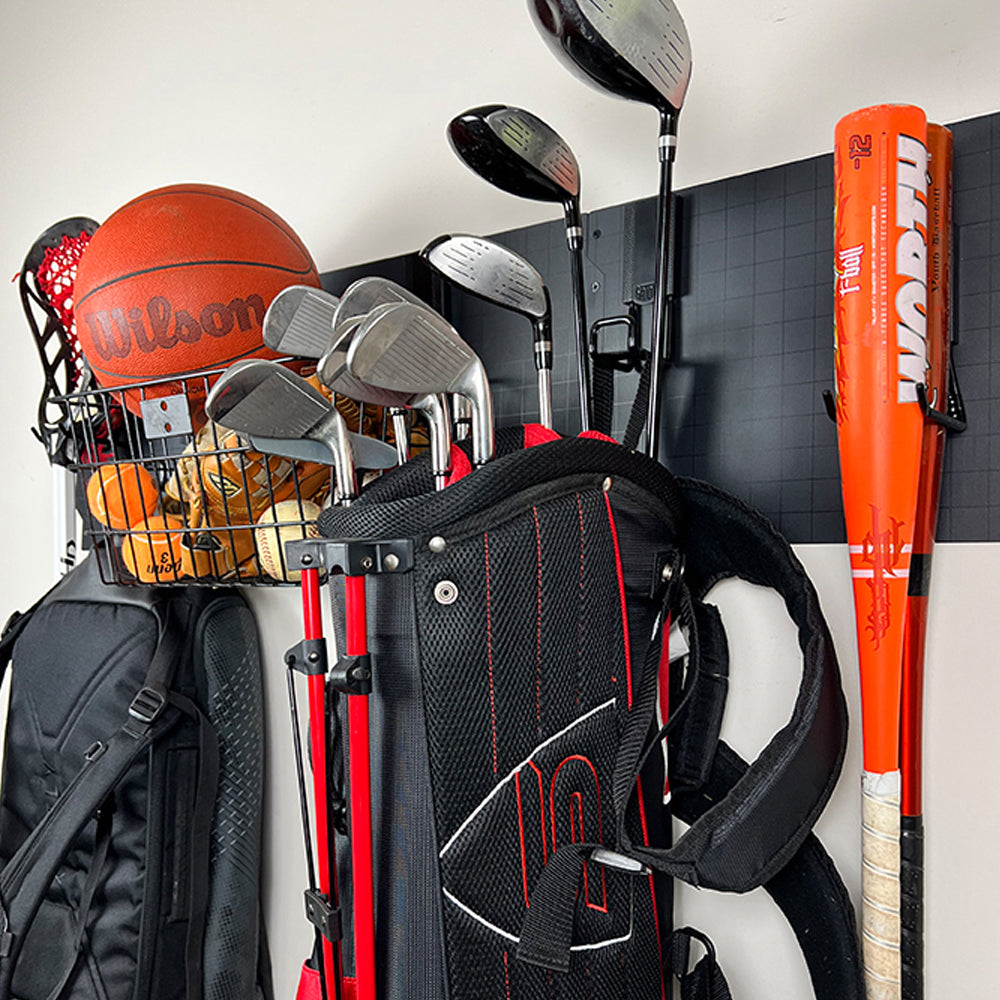Magnetic hooks and wall panel organizing sports gear including golf clubs, baseball bat, and basketball in a garage storage setup.