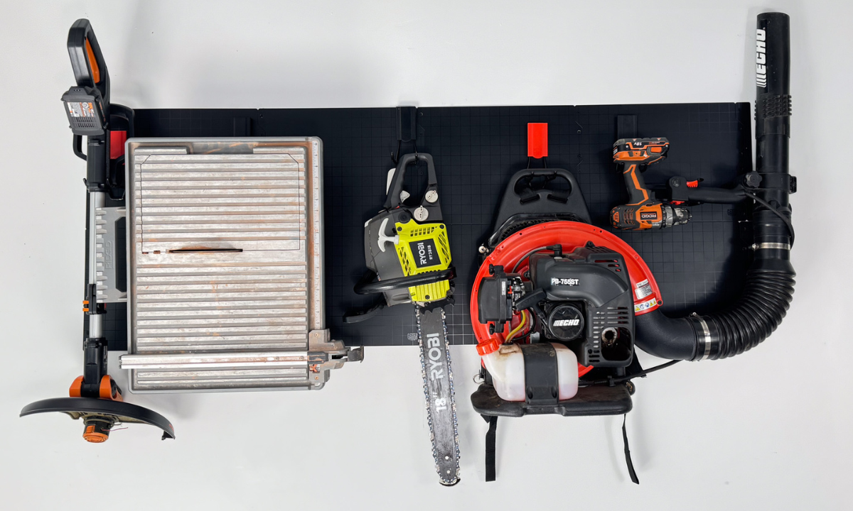 Gator magnetic hooks organize a string trimmer, tile cutter, chainsaw and leaf blower.
