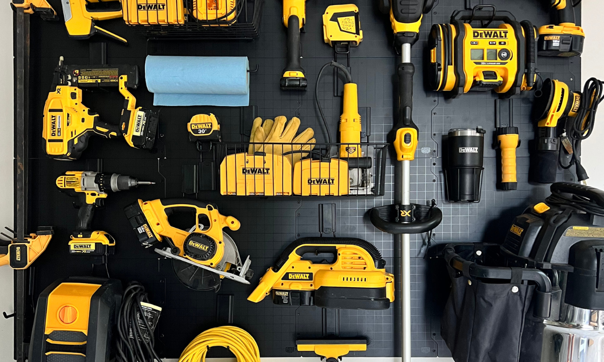A black Gator Steel Wall Panel system mounted on a steel wall holds a variety of DEWALT power and hand tools.