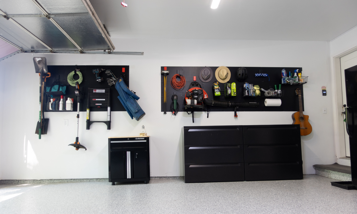 Two Gator Steel Wall Panels with red magnetic hooks organize a shovel, trimmer, ladder, cords and hats.