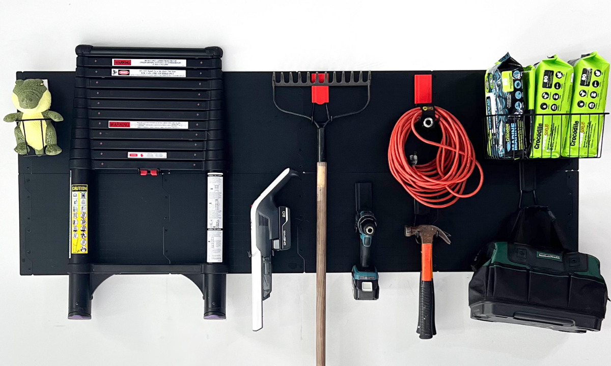Gator Steel Wall Panel holding a ladder, saw, rake, drill, extension cord and hammer.