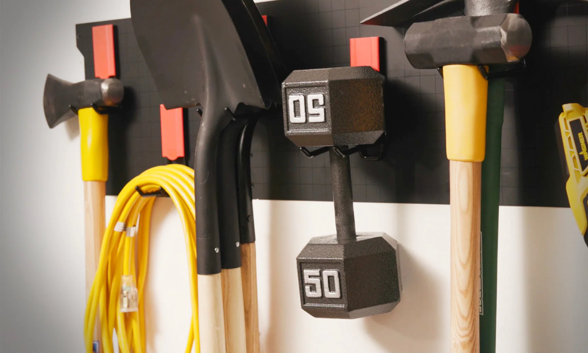 Gator Steel Wall Panel with magnetic hooks holding axes, sledgehammer, extension cord and weight plates.