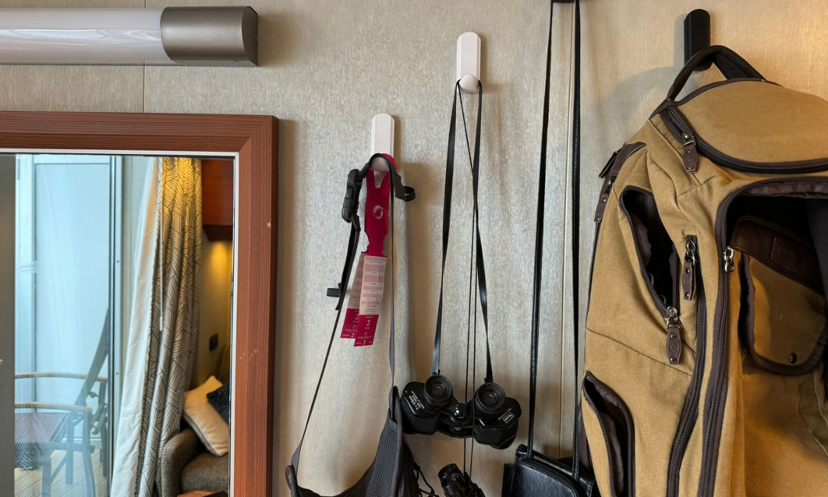 White Gator magnetic hooks hold binoculars, belts and accessories on a steel cruise cabin wall.