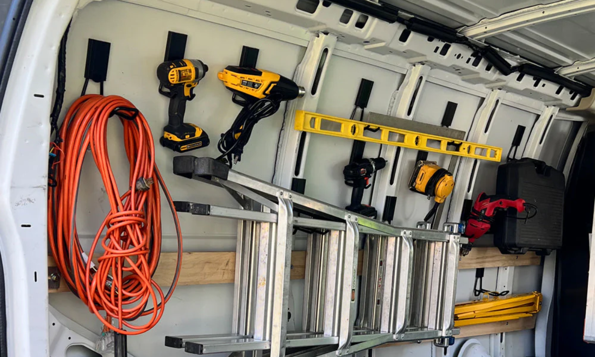 Gator magnetic hooks organize drills, ladder, level, tape measure and extension cord inside a steel van.