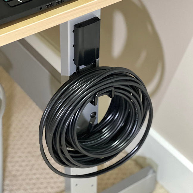 Black 2.5" closed magnetic hook securely holding a cable with a 25 lbs capacity. Ideal for organizing cables, tools, and other equipment on steel surfaces. Perfect for maintaining a tidy and efficient workspace in home garages, workshops, and industrial settings.