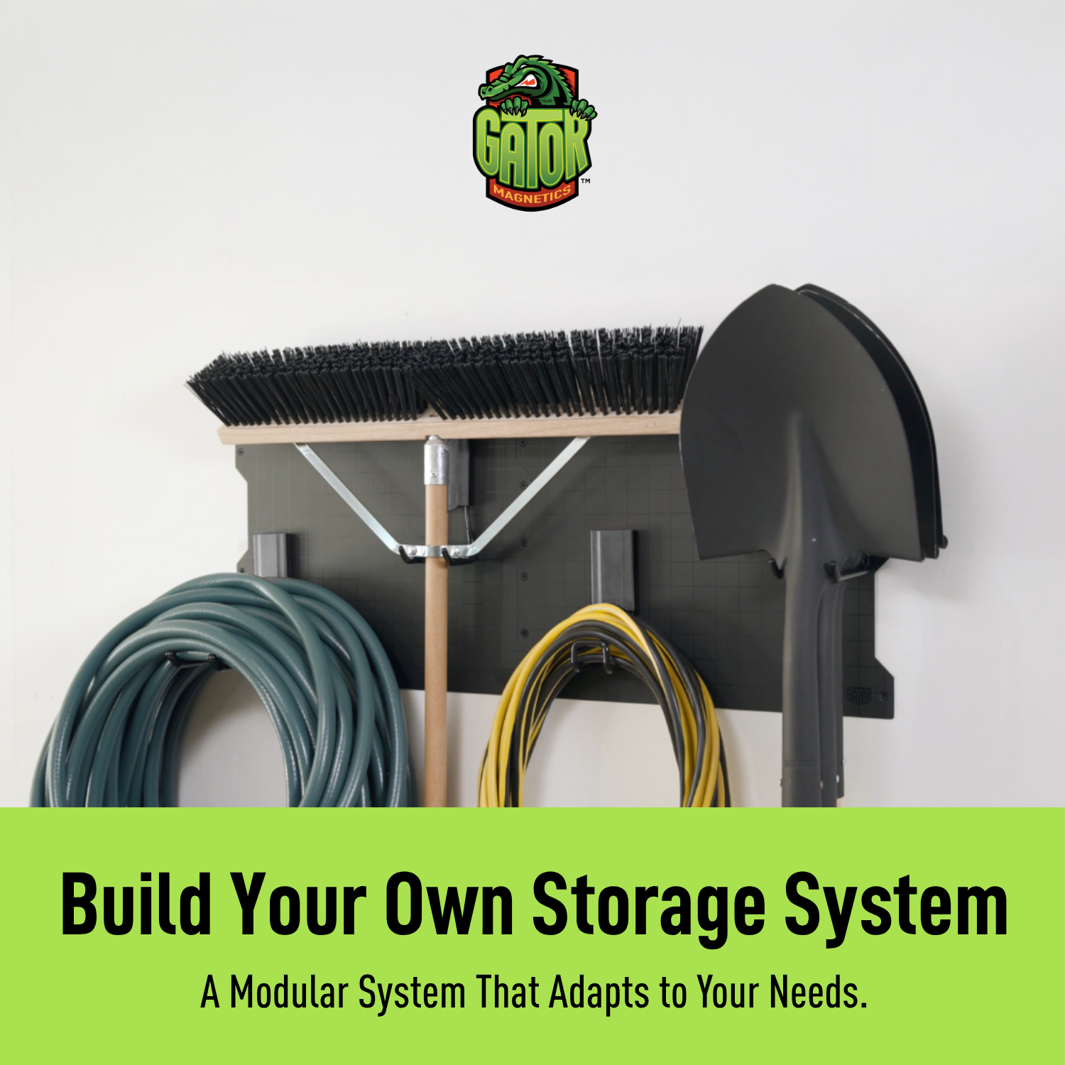 Black 34-inch magnetic wall storage system organizing brooms, hoses and yard tools.