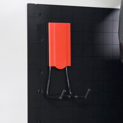 Black hand tools with red handles hanging from a Gator magnetic hook on a black Gator Steel Wall Panel.