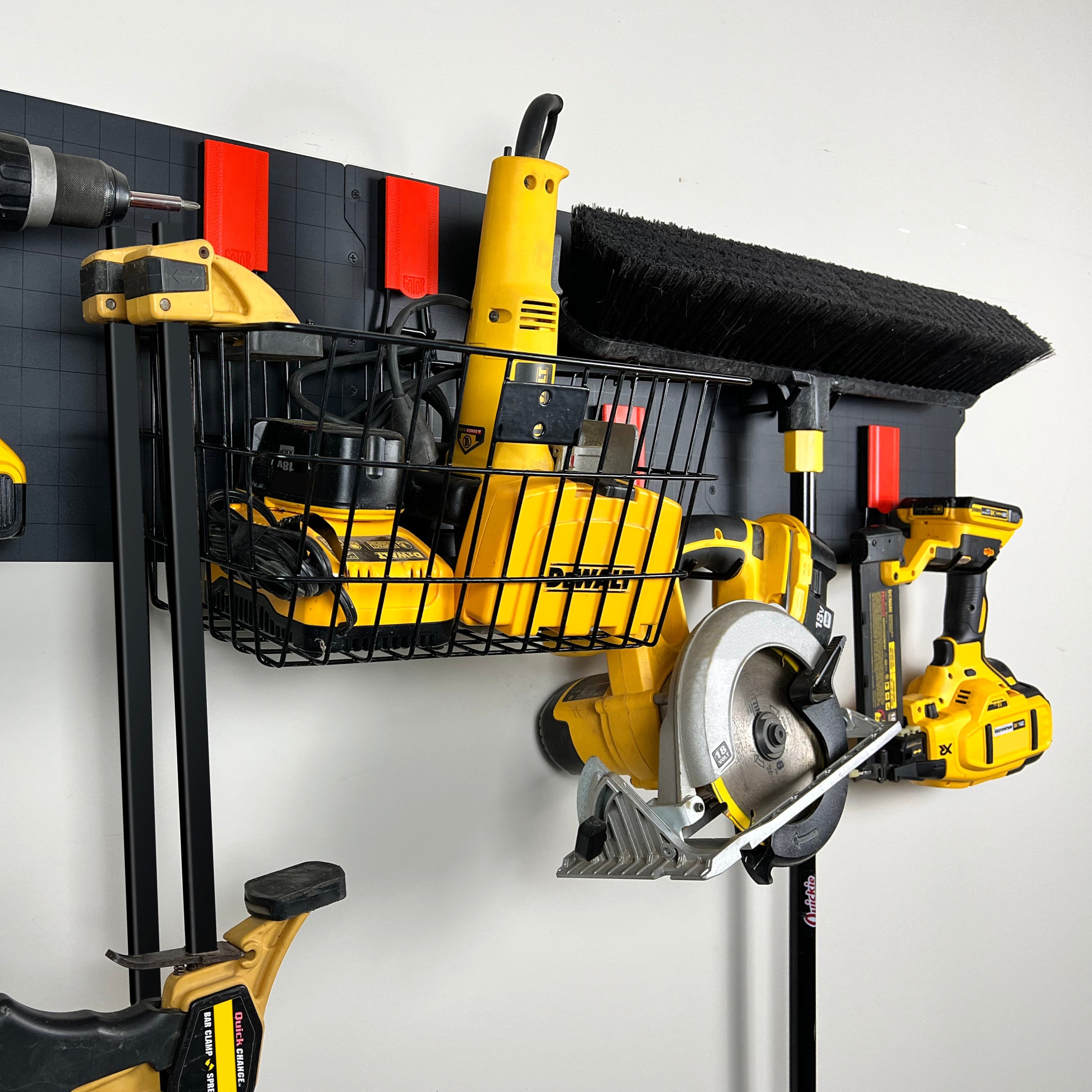 Black Gator magnetic basket holds two battery chargers and a rotary tool on a steel workshop wall.