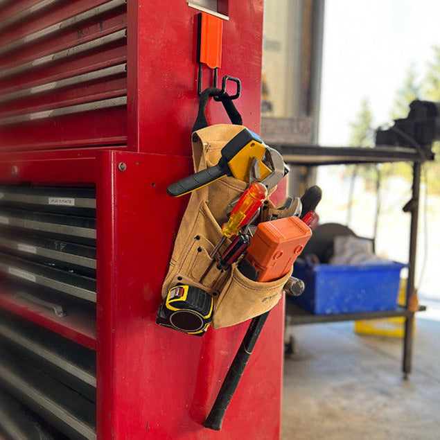 Canvas tool pouch with tape measure, hammer, pliers and screwdrivers hanging from a red Gator MEGA magnetic hook.