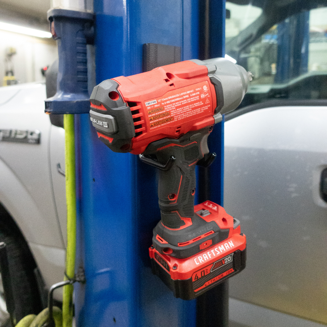 Craftsman cordless impact wrench held by red Gator magnetic hooks on a blue steel post.