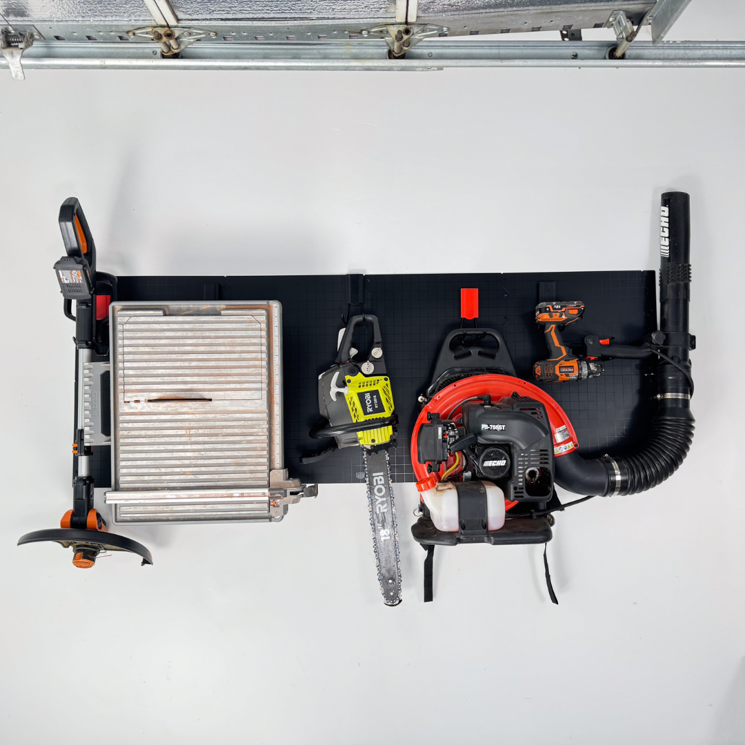Gator magnetic hooks organize a string trimmer, tile cutter, Ryobi chainsaw and Echo leaf blower.