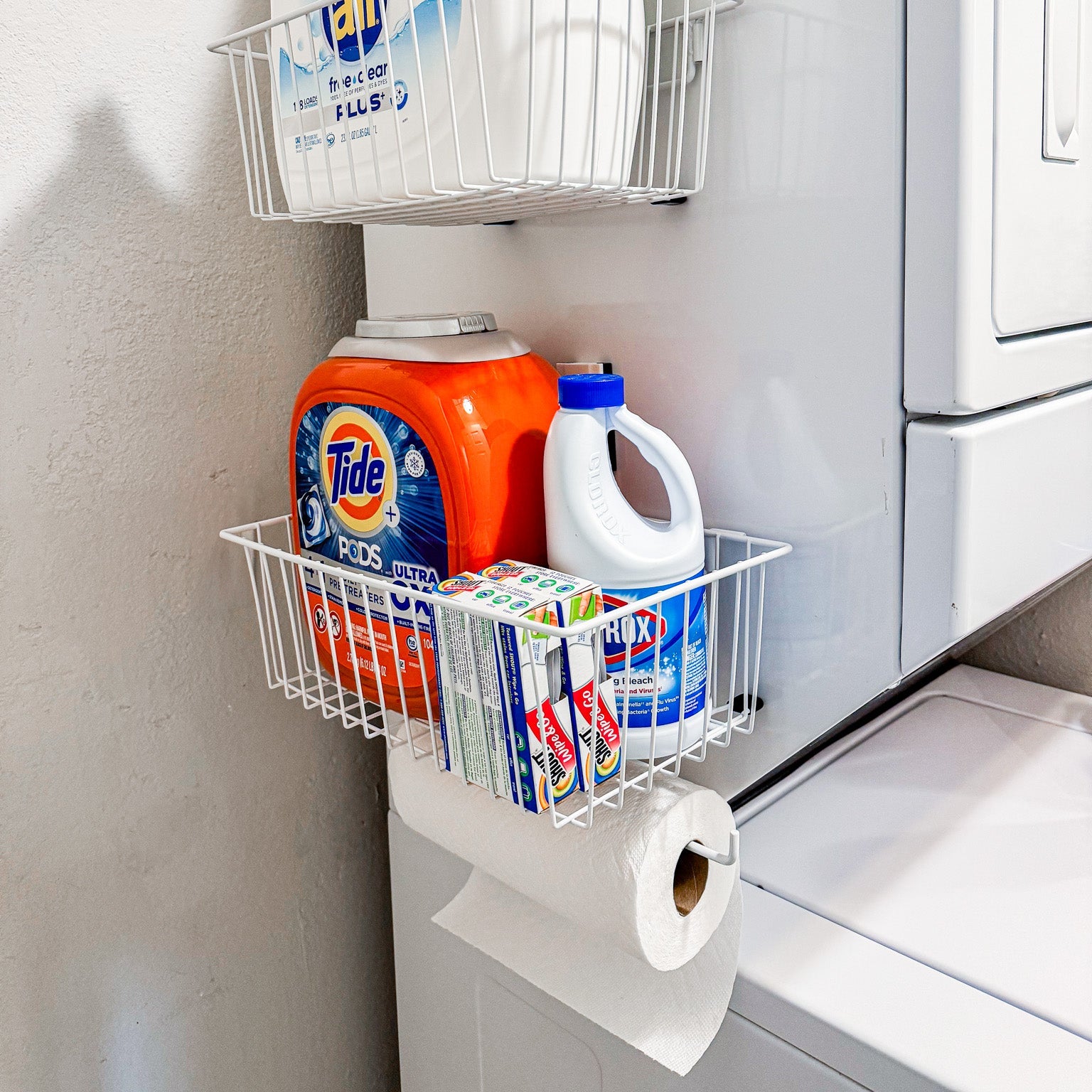 Two white Gator magnetic baskets hold laundry pods, bleach and detergent boxes.