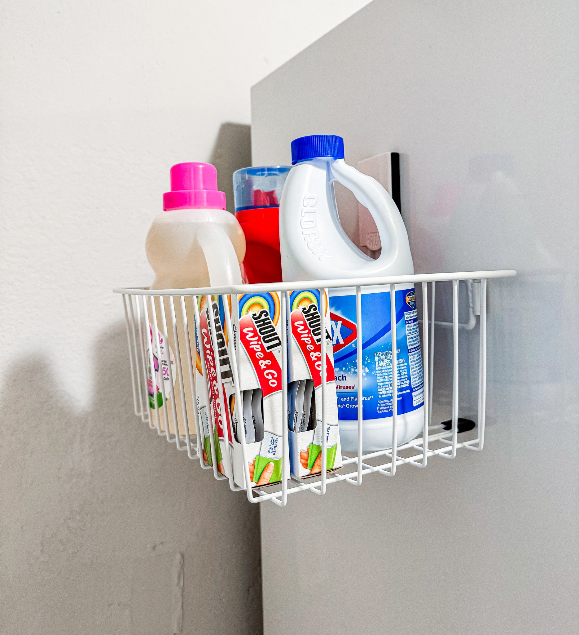 White Gator magnetic basket holding stain remover wipes and a small bottle on a steel laundry surface.