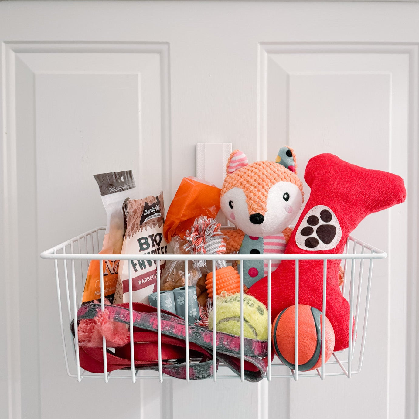 White Gator magnetic basket on a steel door holding dog toys.